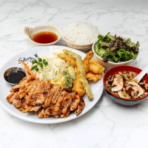 Sakura Chaya's teriyaki chicken with tempura, rice, salad, and mushroom soup on a marble surface.