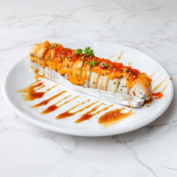 Sakura Chaya's baked salmon sushi roll, topped with orange sauce, roe, and green onions.